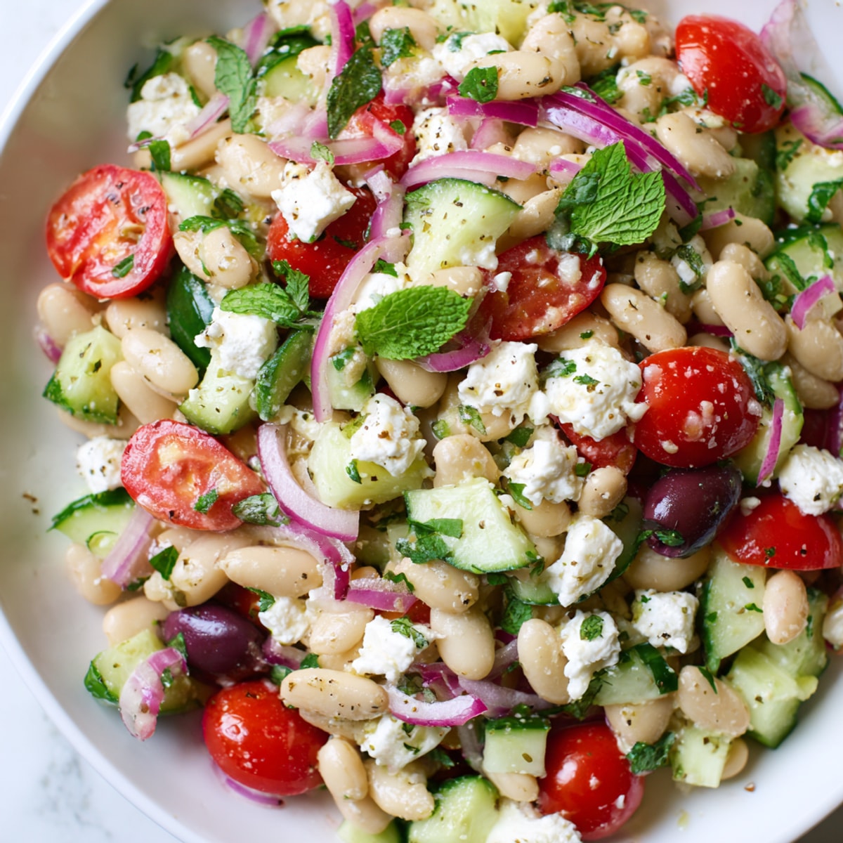 Close-up of vibrant Mediterranean White Bean Salad with Feta crumbles, ready to serve.