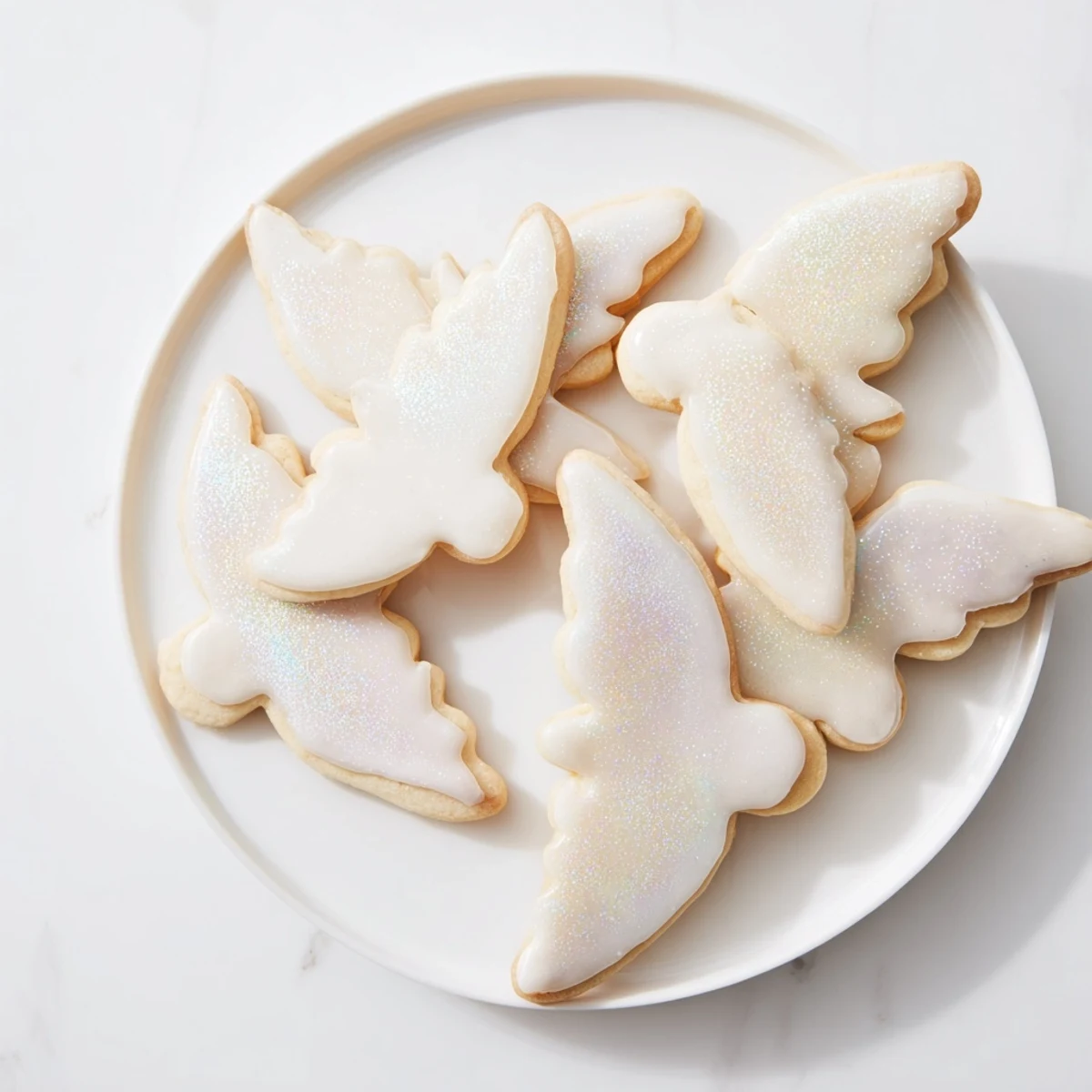 Freshly-baked batch of Angel Wings sugar cookies, ready to be decorated with icing and bright sprinkles.