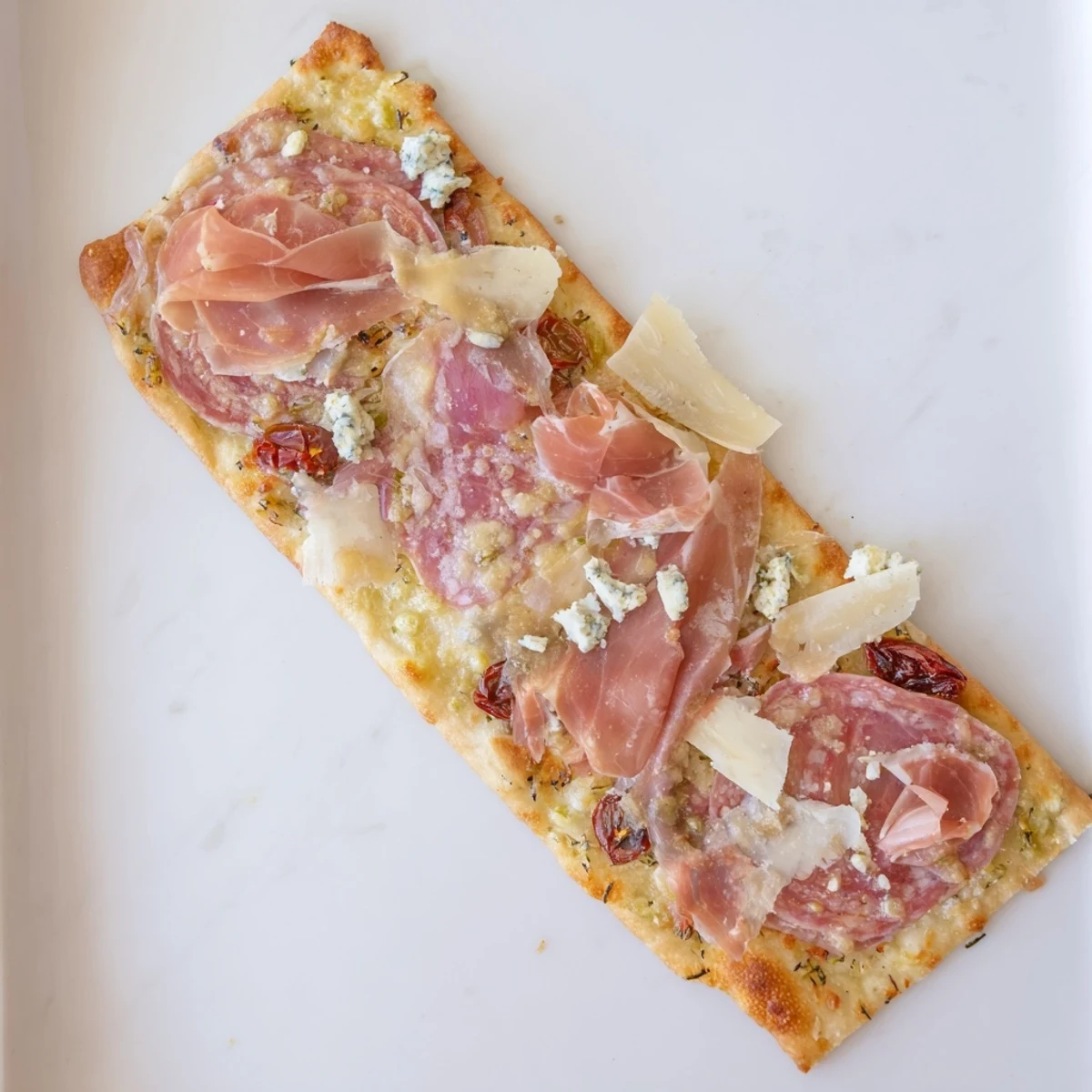 The Rustic Raft appetizer features warm, crispy flatbreads loaded with colorful meats and cheeses.