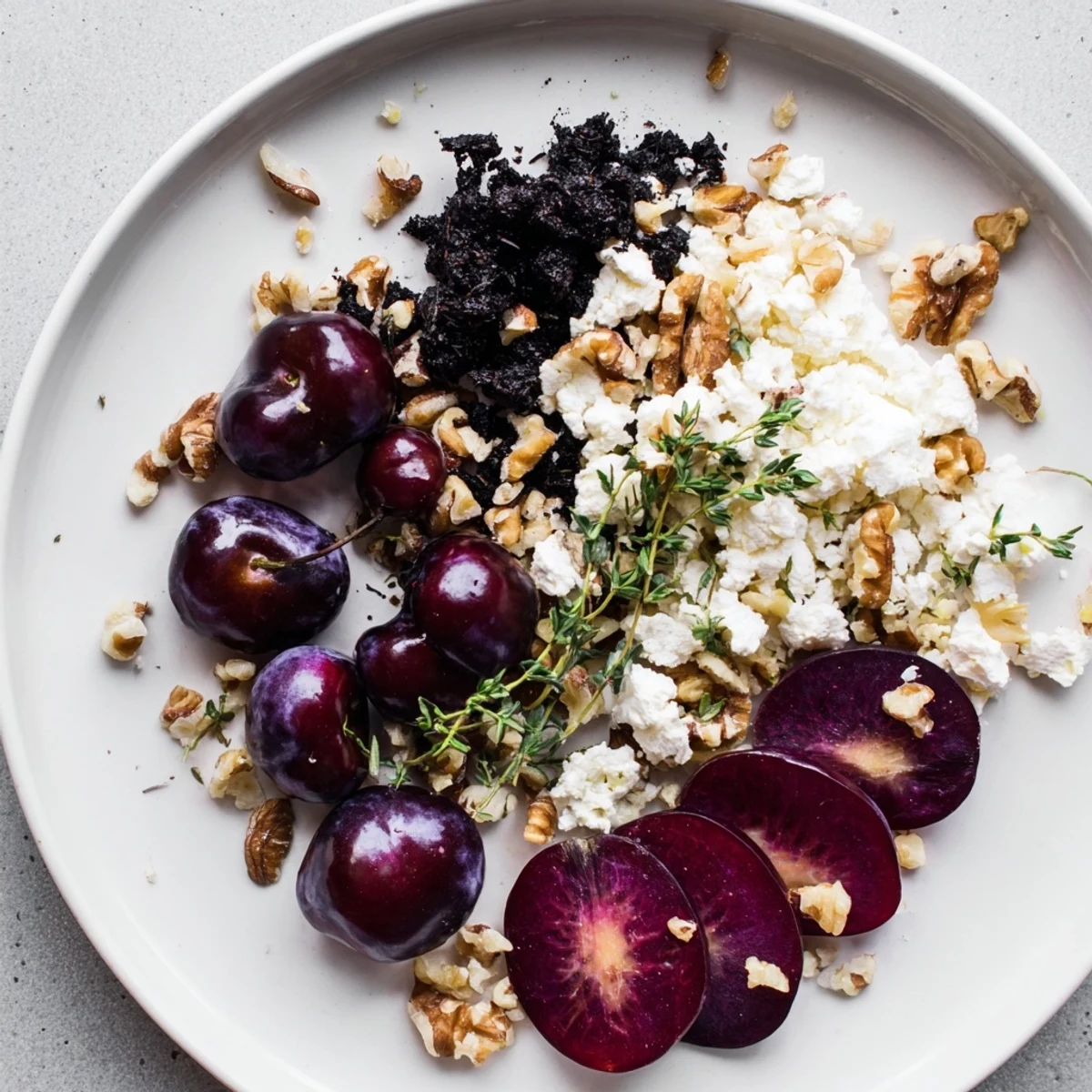 Elegant Midnight Orchard platter showcasing dark cherries, plums, and creamy goat cheese for serving.