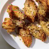 A close-up of delicious baked Parmesan chicken wings with a crispy, herb-infused coating.