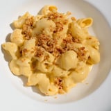 A bubbling baking dish of creamy pumpkin mac & cheese, ideal for a comforting vegetarian meal.
