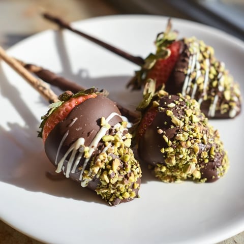 Freshly made chocolate-dipped strawberry skewers glistening with dark chocolate and sprinkled nuts, perfect dessert.