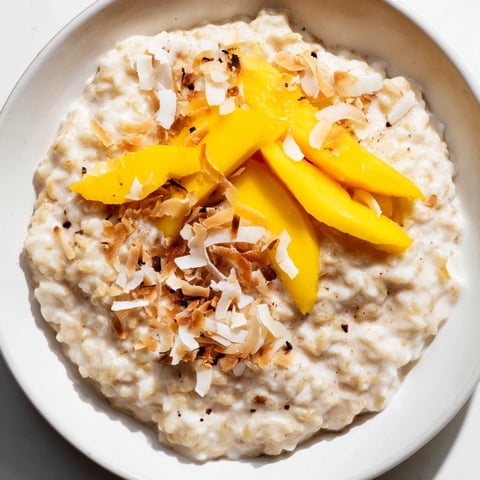 A steaming bowl of Toasted Coconut Rice Pudding, garnished with golden toasted coconut flakes.