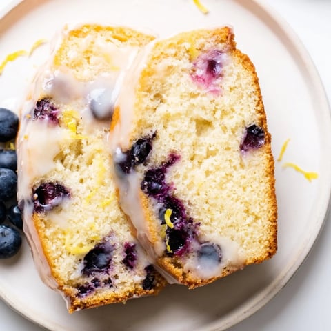 Warm, golden Lemon Blueberry Yogurt Loaf, studded with juicy blueberries and drizzled with glaze.