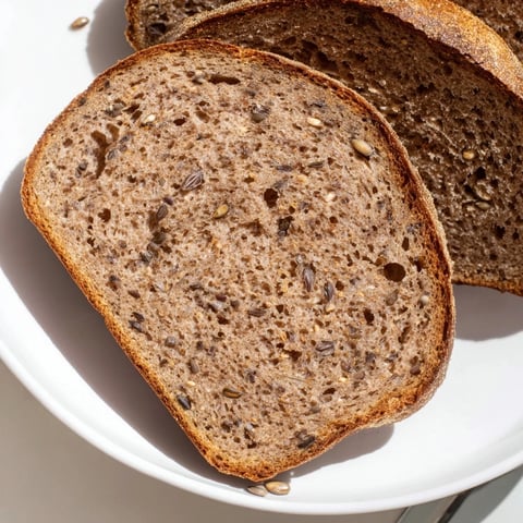 Crusty, dark Estonian Leib sourdough: a hearty, aromatic bread ready to slice and enjoy.