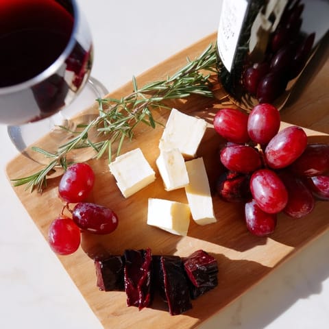 Festive Ruby Red Wine Stain Board: a stunning arrangement of red wine-infused cheeses and charcuterie.