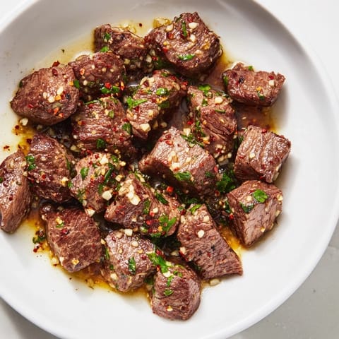 Delicious garlic butter steak bites, cooked with browned edges and fresh parsley sprinkled on top.