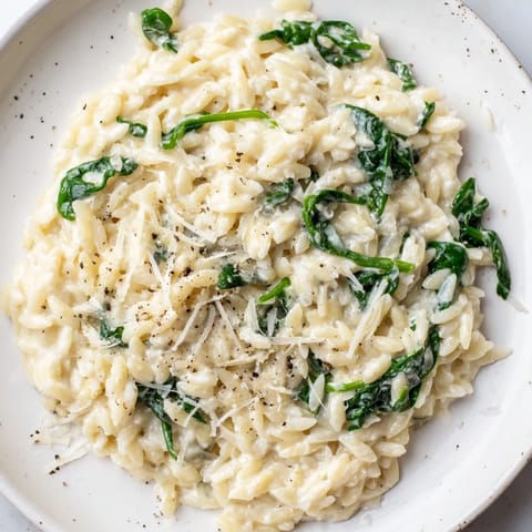 The warm, creamy texture of this Creamy Spinach Orzo is highlighted by fresh Parmesan cheese.