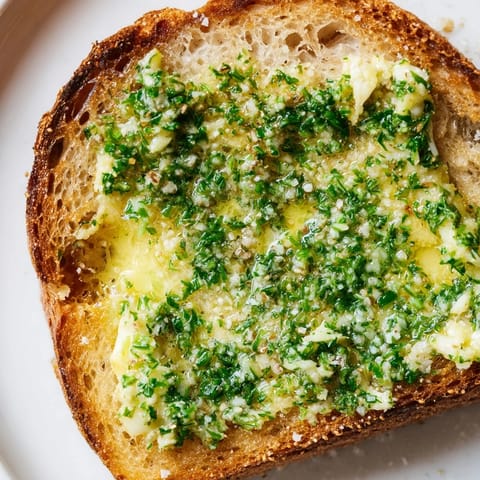 A close-up of Herb Butter Toast highlights the crispy, crusty bread and vibrant green herbs.