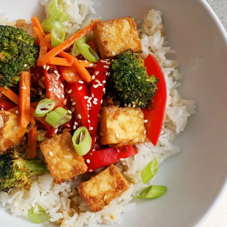 Vibrant Honey Garlic Tofu Bowls, featuring vegetables and tofu coated in a sweet and savory sauce, over rice.