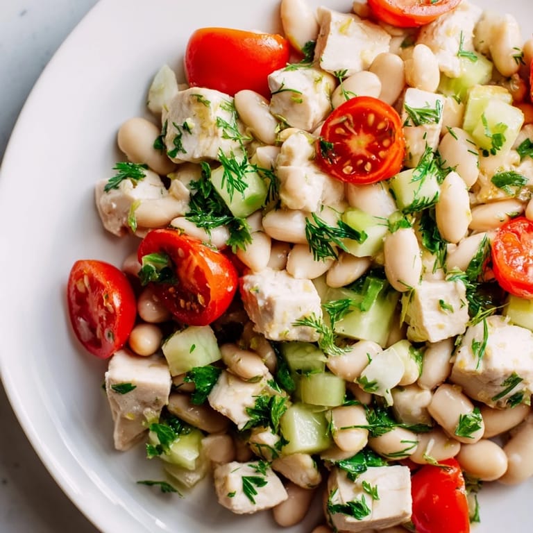 Fresh Lemony White Bean Chicken Salad garnished with parsley, lemon zest, and olive oil, perfect for a light summer lunch.