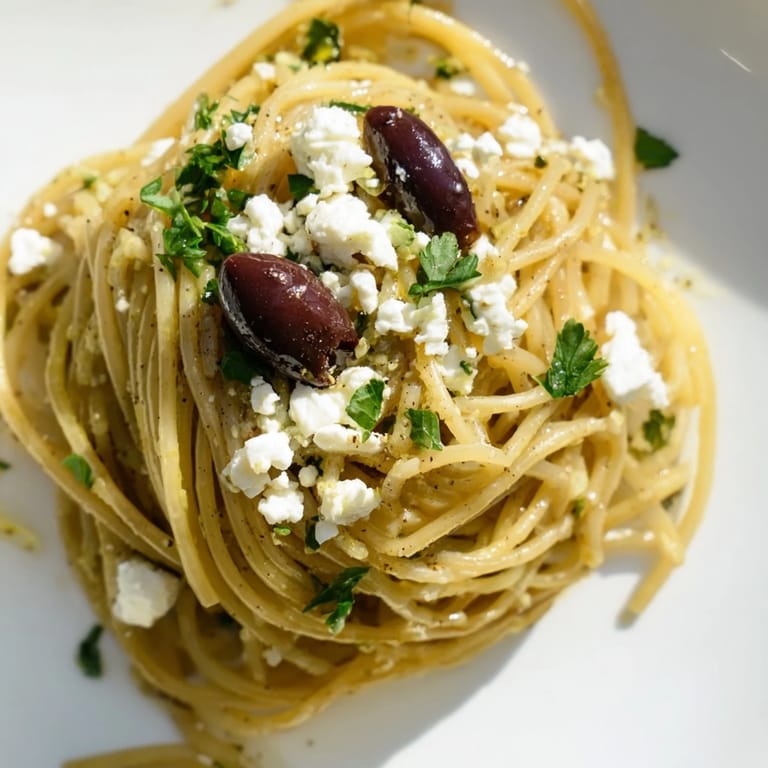 A colorful skillet of Greek Chicken Spaghetti features herbs, lemony dressing, and tomato sauce coating spaghetti for an easy, vibrant dinner.